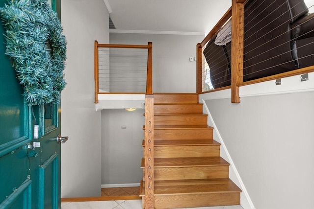 staircase featuring ornamental molding and tile patterned flooring