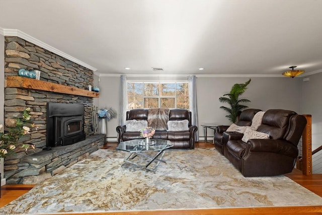 living room with baseboard heating, ornamental molding, wood-type flooring, and a wood stove