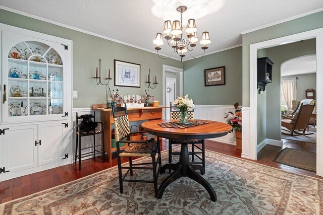 77 Center St, Ashburnham, MA 01430 - dining room with wood finished floors, arched walkways, a chandelier, crown molding, and a wainscoted wall