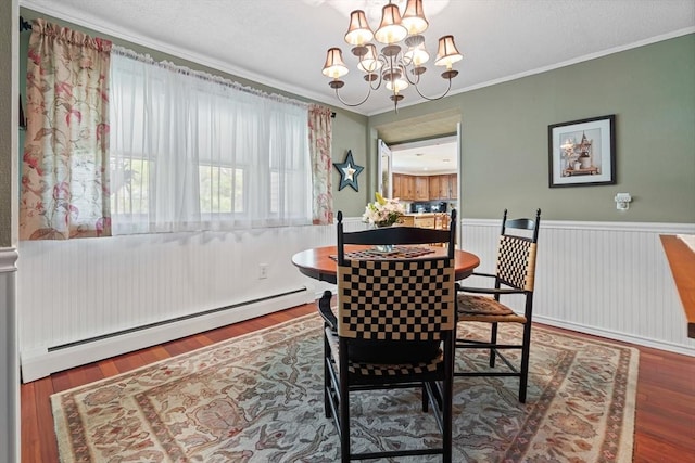 77 Center St, Ashburnham, MA 01430 - dining space with a baseboard radiator, a chandelier, wood finished floors, wainscoting, and ornamental molding