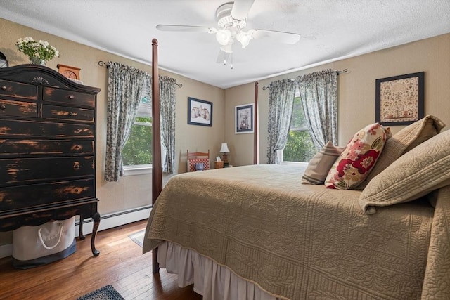 77 Center St, Ashburnham, MA 01430 - bedroom featuring multiple windows, a baseboard radiator, wood-type flooring, and ceiling fan