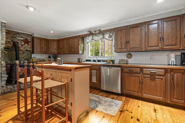 77 Center St, Ashburnham, MA 01430 - kitchen featuring stainless steel dishwasher, a sink, a wood stove, light wood-style flooring, and a kitchen island