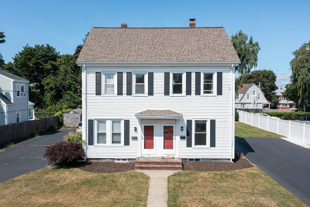 colonial-style house featuring a front lawn