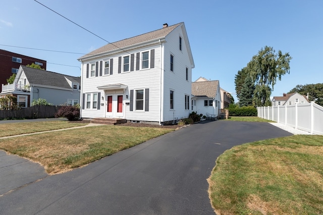 colonial home featuring a front lawn