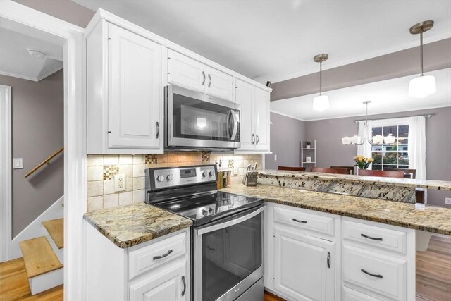 2 Ridge Rd, East Longmeadow, MA 01028 - kitchen featuring appliances with stainless steel finishes, ornamental molding, a peninsula, backsplash, and light wood-type flooring