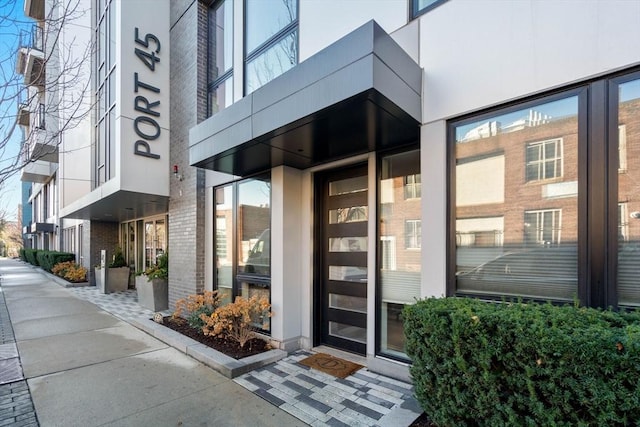 doorway to property featuring brick siding