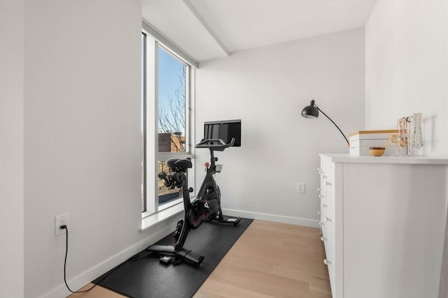 exercise room with wood finished floors and baseboards