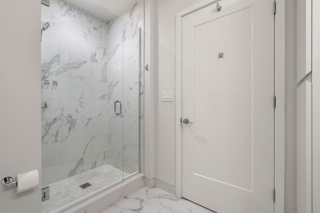 bathroom with marble finish floor, a marble finish shower, and baseboards