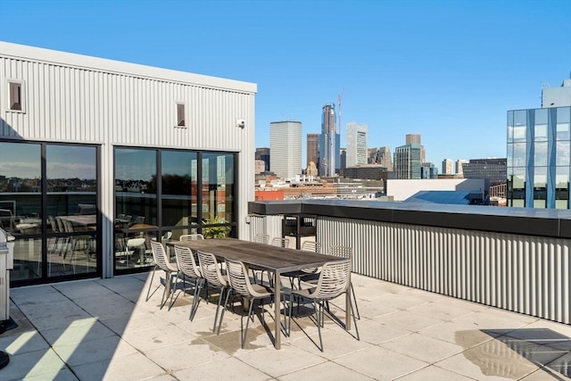 view of patio / terrace with a view of city and a balcony