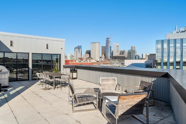 view of patio featuring outdoor dining area and a city view