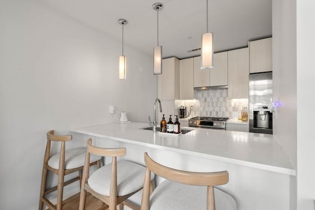 kitchen featuring stainless steel appliances, a breakfast bar, a peninsula, and tasteful backsplash