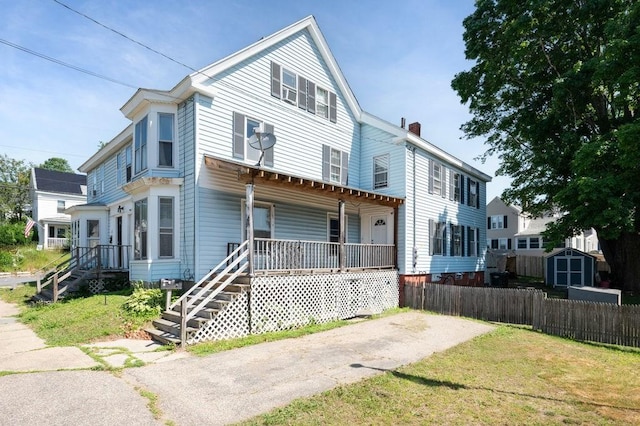 17-19 Whitehall Rd, Amesbury, MA 01913 - view of front of property with covered porch, a storage shed, a chimney, and stairs
