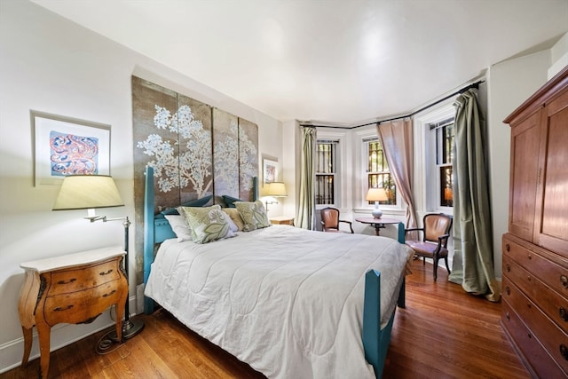 bedroom with dark hardwood / wood-style floors