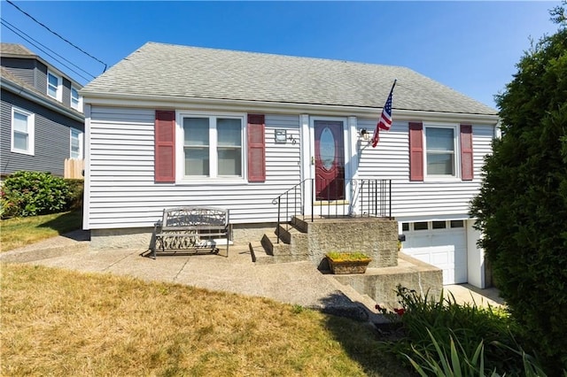 view of front of property featuring a front yard and a garage