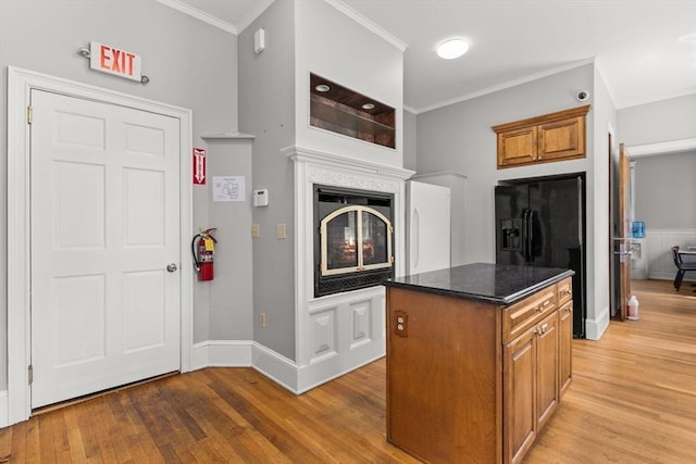 543 Newport Ave, Attleboro, MA 02703 - kitchen with black fridge with ice dispenser, light wood-style floors, ornamental molding, brown cabinetry, and a kitchen island
