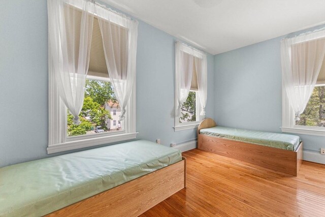 543 Newport Ave, Attleboro, MA 02703 - unfurnished bedroom featuring a baseboard heating unit and wood finished floors