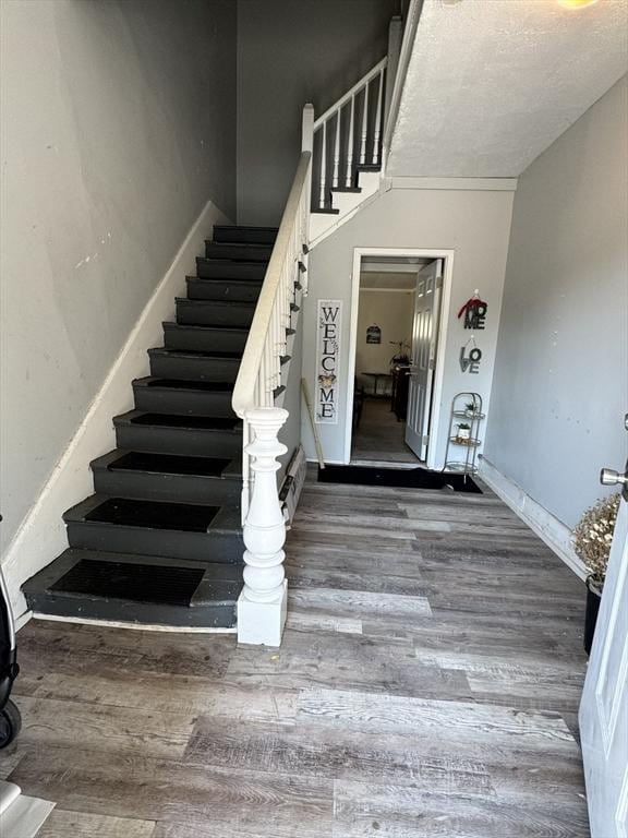 stairway with baseboards and wood finished floors