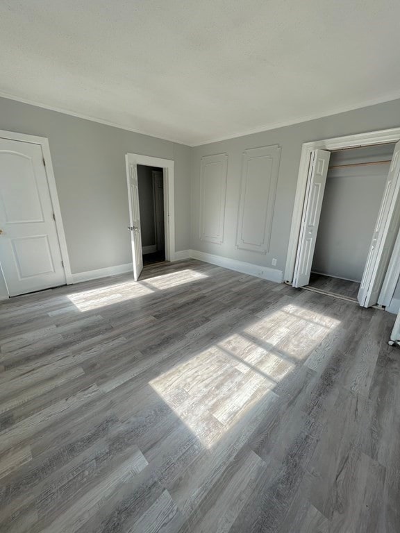 unfurnished bedroom with a closet, baseboards, and wood finished floors