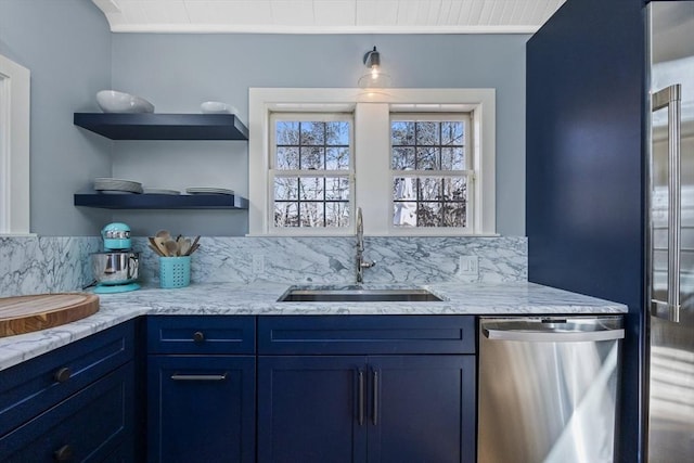 kitchen featuring light stone counters, blue cabinetry, open shelves, a sink, and dishwasher