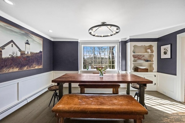 dining area featuring ornamental molding, a baseboard radiator, and wainscoting