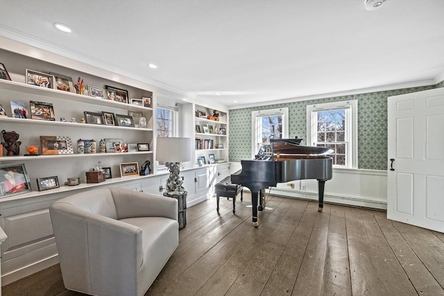 sitting room with dark wood-style floors, crown molding, baseboard heating, wainscoting, and wallpapered walls