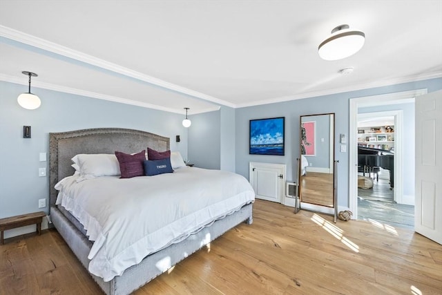 bedroom featuring ornamental molding and light wood-type flooring