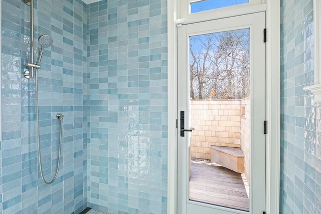 full bathroom with a tile shower and tile walls