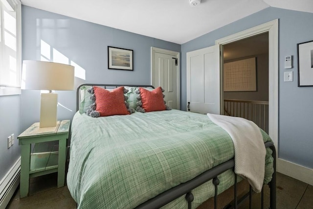 bedroom featuring lofted ceiling, baseboard heating, carpet, and a closet