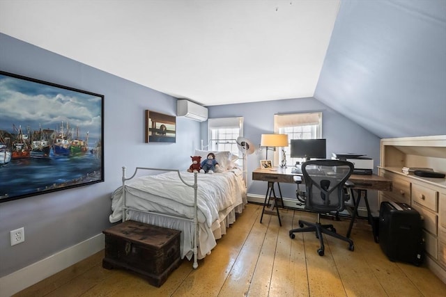 bedroom featuring lofted ceiling, a wall mounted AC, hardwood / wood-style flooring, and baseboards