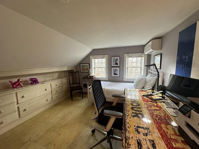 office space featuring vaulted ceiling, a wall unit AC, and light wood-style flooring