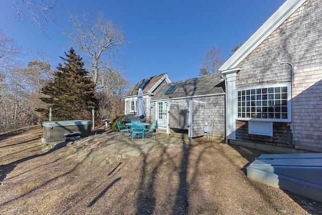 view of home's exterior with a patio area and a hot tub