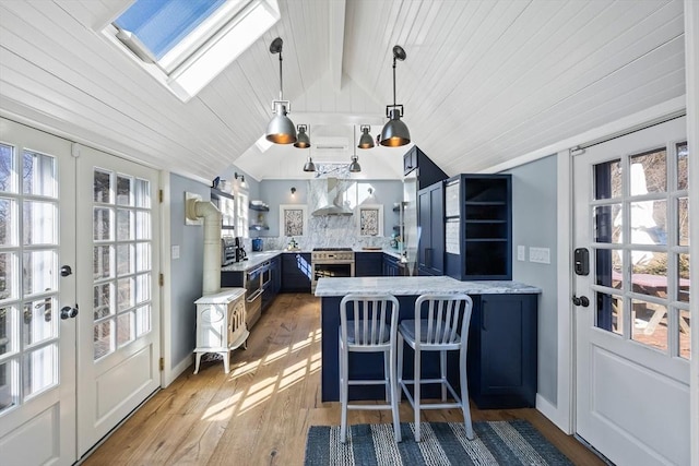 sunroom / solarium featuring vaulted ceiling with skylight, french doors, and wooden ceiling