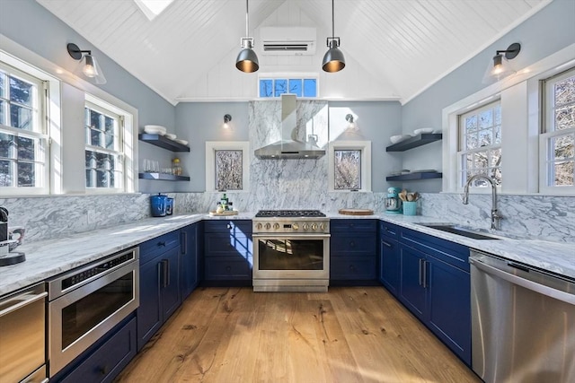 kitchen with wall chimney exhaust hood, appliances with stainless steel finishes, blue cabinets, open shelves, and a sink