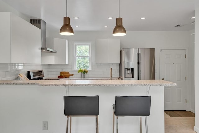 215 Norfolk St Unit 2, Cambridge, MA 02139 - kitchen featuring stainless steel refrigerator with ice dispenser, wall chimney exhaust hood, modern cabinets, a peninsula, and recessed lighting