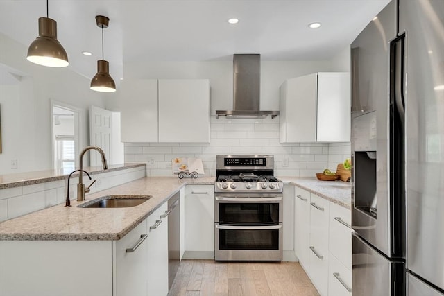 215 Norfolk St Unit 2, Cambridge, MA 02139 - kitchen with stainless steel appliances, wall chimney exhaust hood, white cabinetry, light stone counters, and recessed lighting
