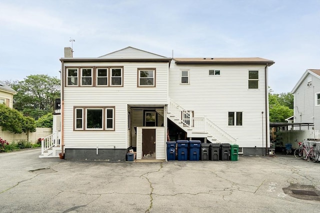 215 Norfolk St Unit 2, Cambridge, MA 02139 - rear view of house featuring stairs, a chimney, entry steps, and a patio area
