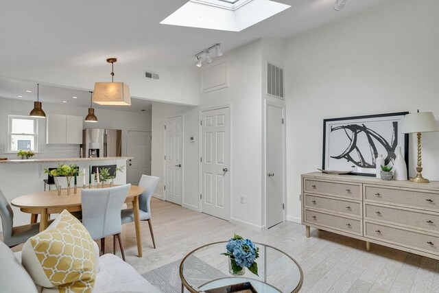 215 Norfolk St Unit 2, Cambridge, MA 02139 - living area featuring a skylight, light wood-style flooring, rail lighting, and high vaulted ceiling