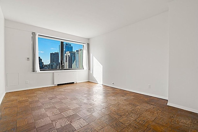 unfurnished room featuring radiator heating unit