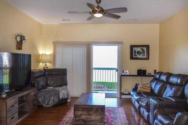 living room with dark wood-style flooring, a ceiling fan, and visible vents