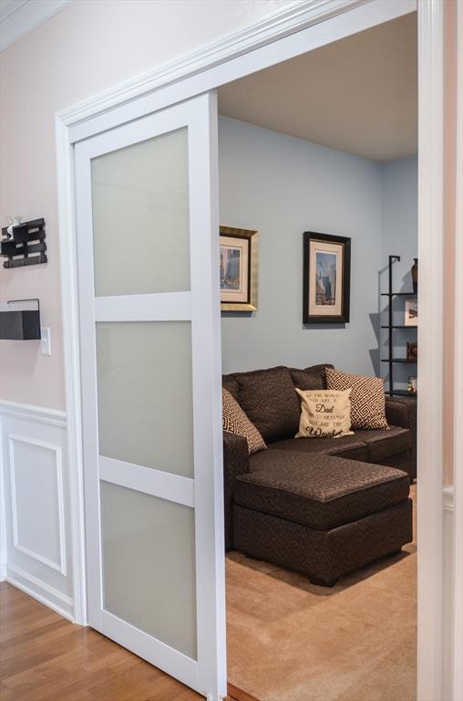 living area with wainscoting and wood finished floors
