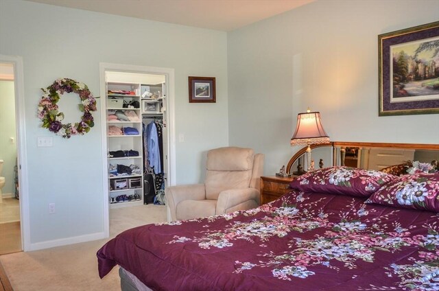 carpeted bedroom with a closet, baseboards, and a spacious closet