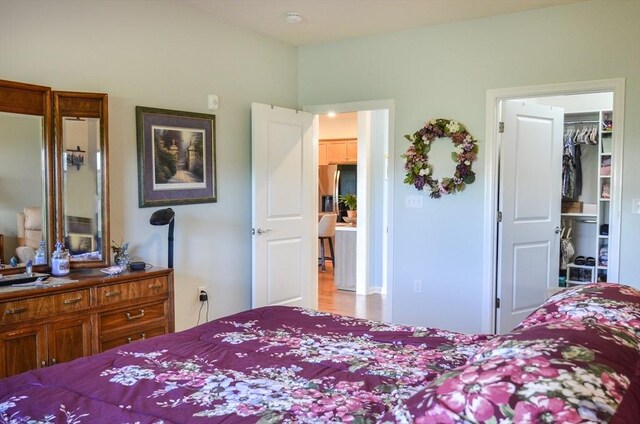 bedroom featuring a walk in closet and wood finished floors