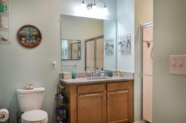 full bath with vanity, a shower stall, and toilet