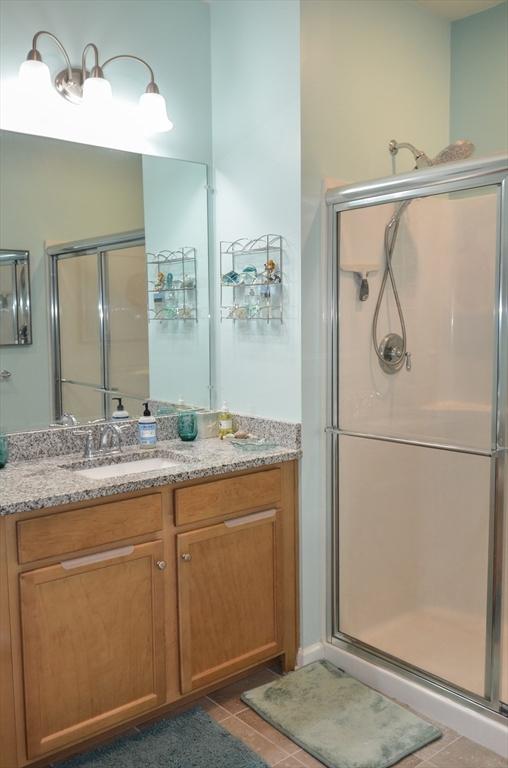 bathroom with vanity, tile patterned flooring, and a shower stall