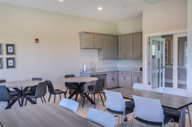 kitchen with gray cabinetry, light countertops, recessed lighting, and a sink