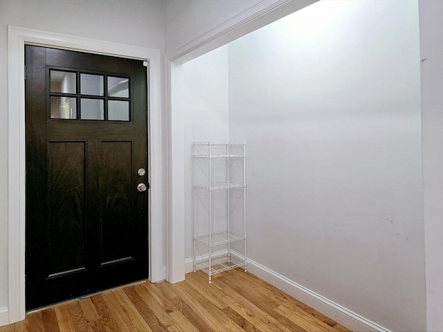 foyer entrance with light wood-style flooring and baseboards