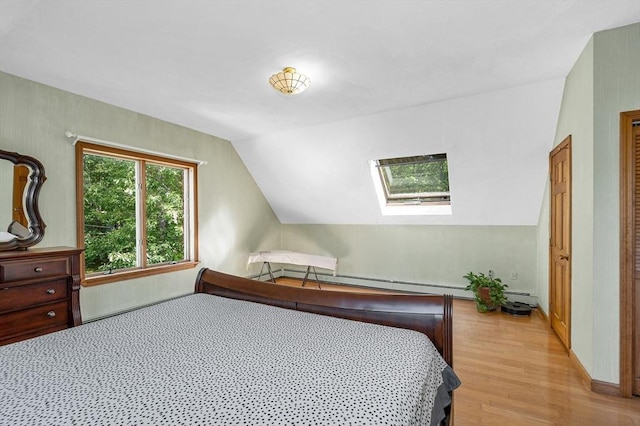 8 Horseshoe Dr, Acton, MA 01720 - bedroom with light wood-style flooring, lofted ceiling, a skylight, and a baseboard radiator