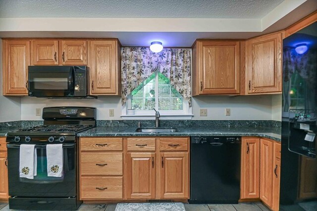 20 Bowdoin Dr, Haverhill, MA 01830 - kitchen with black appliances, light tile patterned floors, dark stone counters, and brown cabinetry