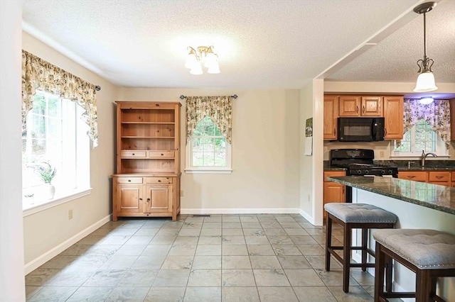 20 Bowdoin Dr, Haverhill, MA 01830 - kitchen featuring black appliances, a breakfast bar area, a textured ceiling, hanging light fixtures, and brown cabinetry