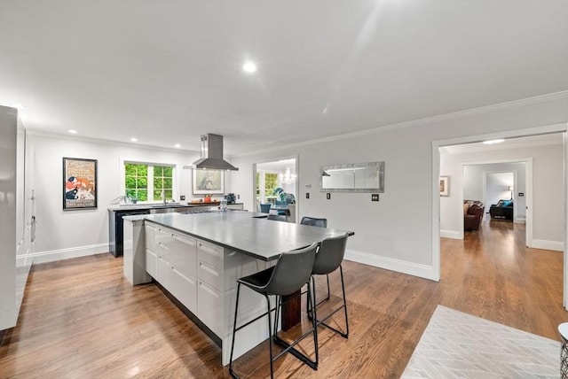 176 Spring St, Hopkinton, MA 01748 - kitchen with a large island, range hood, white cabinetry, a breakfast bar area, and ornamental molding